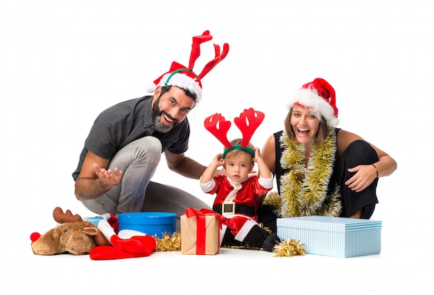 Foto piccolo bambino adorabile con i suoi genitori alle feste di natale su fondo bianco isolato