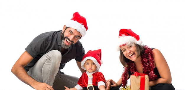 孤独な白い背景にクリスマスパーティーで両親と愛らしい小さな赤ちゃん