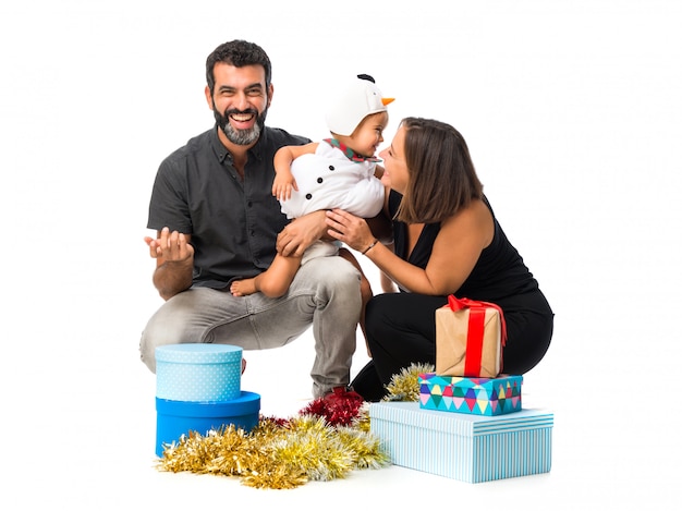 Очаровательны маленький ребенок с его родителями на рождественские вечеринки на белом фоне