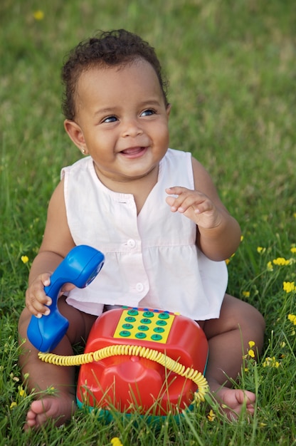 Adorable little black girl with big phone