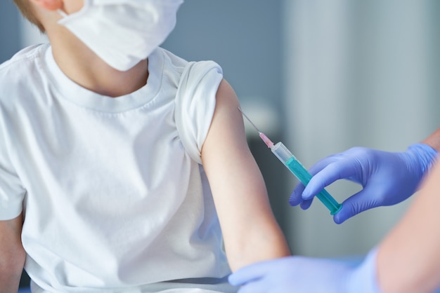 adorable little boy being vaccinate at doctor's office