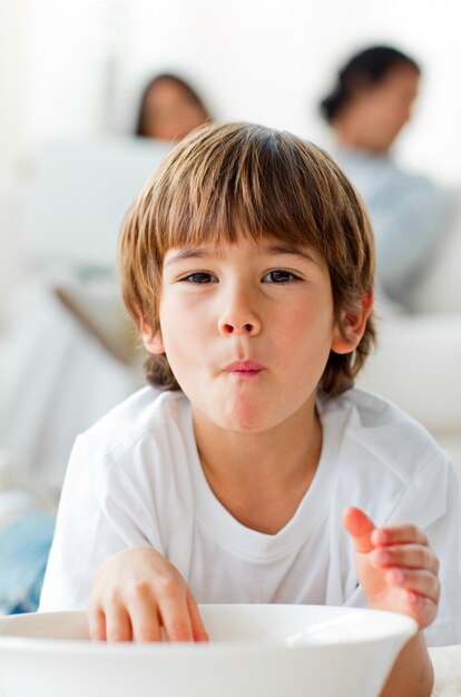 Adorable little boy eating chips lying on the floor