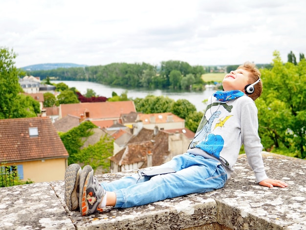 Adorable little boy is listening to music with headphones. He enjoys music.