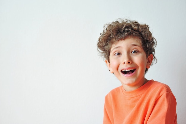 Adorable little boy makes funny faces grimaces and is surprised at something