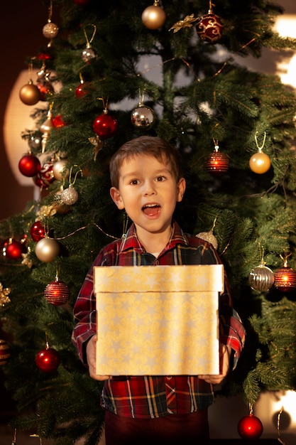 Фото Очаровательный маленький мальчик в рождественскую ночь дома