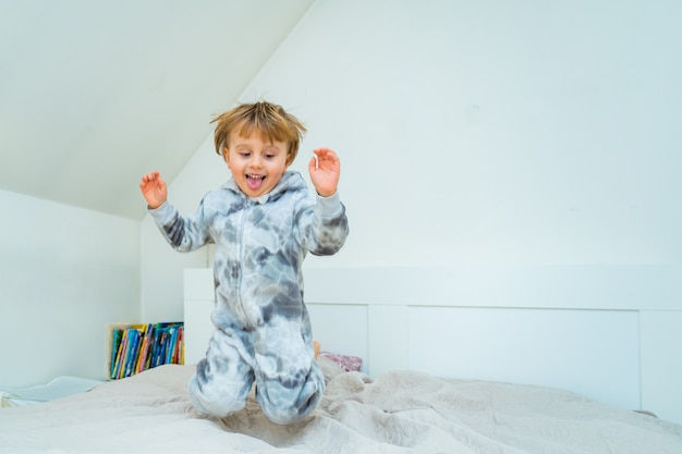 Adorable little boy of three years old playing in bedroom at home