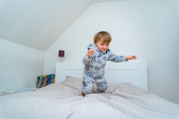 Adorable little boy of three years old playing in bedroom at home