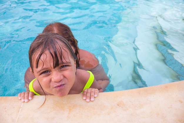 Adorable little caucasian girl in the swimming pool in summer Little girl enjoying hotel pool on vacation trip