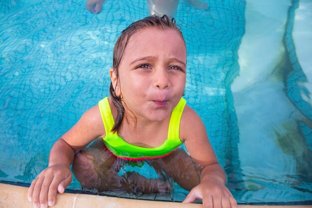 Adorabile bambina caucasica in piscina in estate bambina che si gode la piscina dell'hotel in vacanza