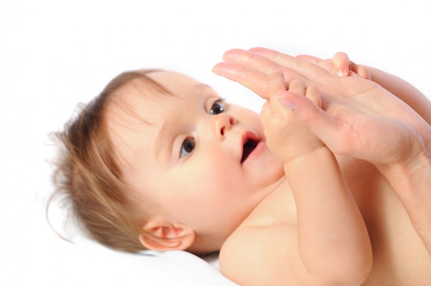 Adorable little child holding palm mother with hands.