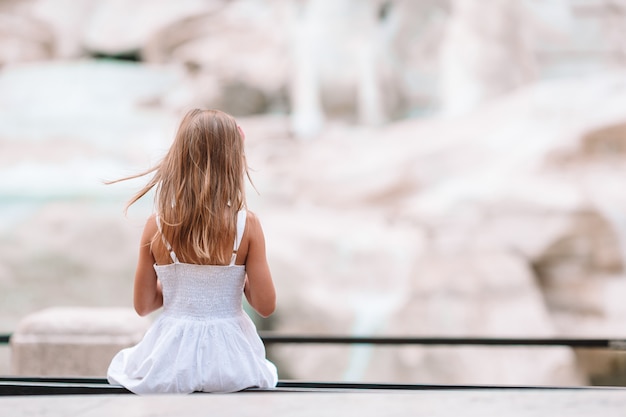 Adorable little girl background Trevi Fountain, Rome, Italy.