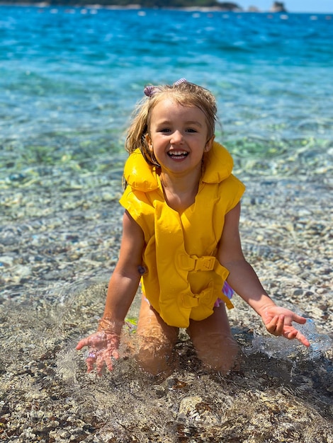 Foto bambina adorabile in spiaggia durante le vacanze estive