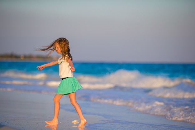 Adorable little girl at beach having a lot of fun in shallow water