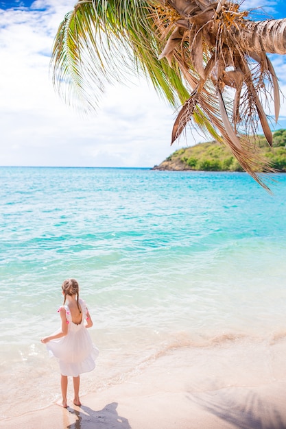 Adorable little girl at beach having a lot of fun in shallow water