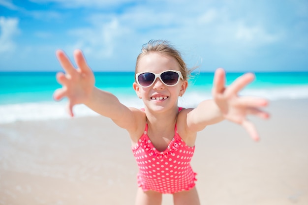 Adorable little girl at beach having a lot of fun