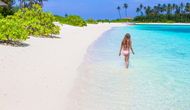 Adorable little girl at beach during summer vacation