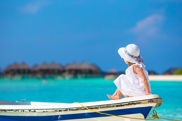 Очаровательная маленькая девочка на лодке во время летних каникул