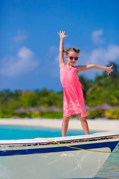 Очаровательная маленькая девочка на лодке во время летних каникул