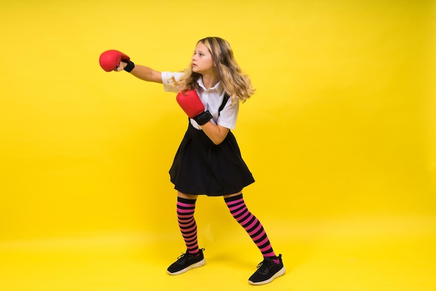 An adorable little girl boxer practicing punches in studio