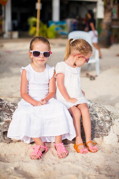 Adorable little girl drinking fresh watermelon on the beach