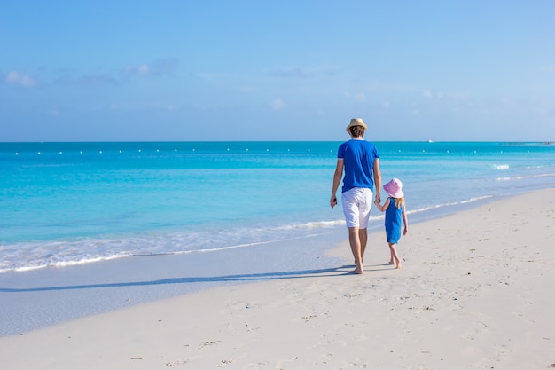 Adorable little girl and father at beach during summer vacation