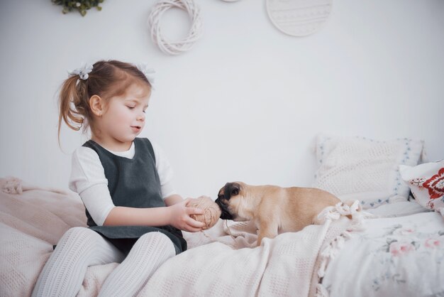 かわいいパグを餌のかわいい女の子。彼女は子犬を買った。親友