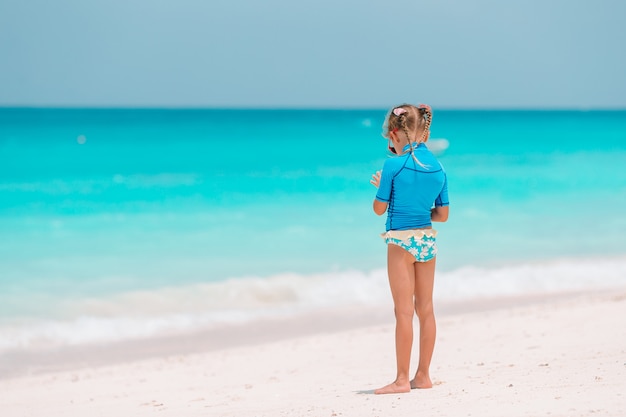 Adorable little girl have fun at tropical beach during vacation