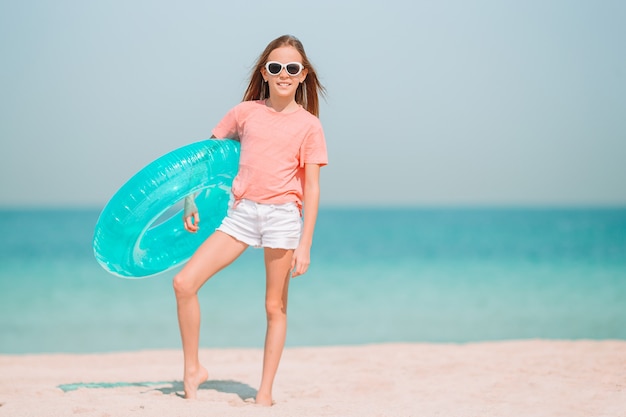 Adorable little girl have fun at tropical beach during vacation