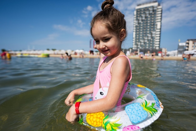 Adorable little girl having fun on the beach at hot summer day