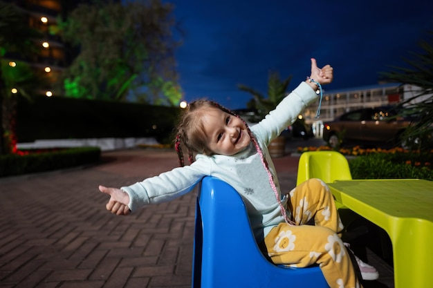 Adorable little girl having fun on a playground in the evening