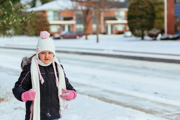 Adorable little girl having fun on winter day little girl playing in the street in winter