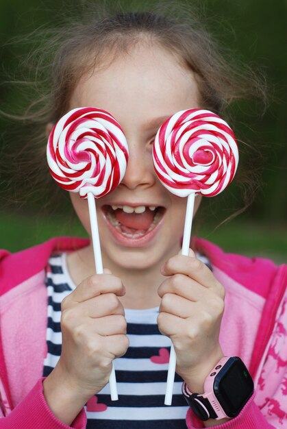 Adorable little girl holding swirl lollipop. Having fun. 