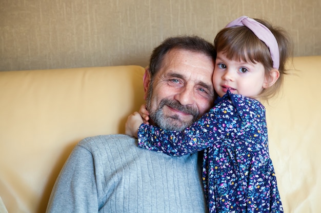 Foto bambina adorabile che abbraccia suo nonno barbuto