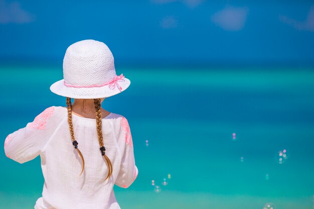 Adorable little girl making soap bubbles during summer vacation