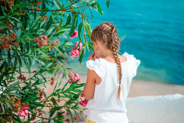 Bambina adorabile alla vecchia via del villaggio tradizionale greco tipico