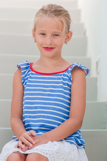 Adorable little girl at old street of typical greek traditional village