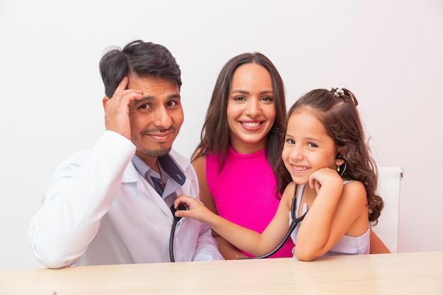 Adorable little girl in pediatrics playing listening to the doctor's heart. pediatrics day