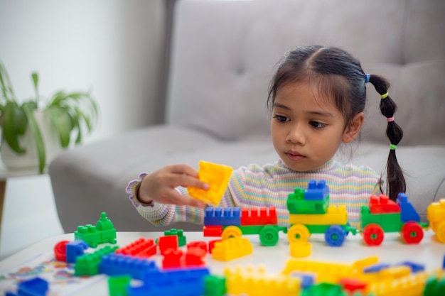 Adorable little girl playing toy blocks in a bright roomx9