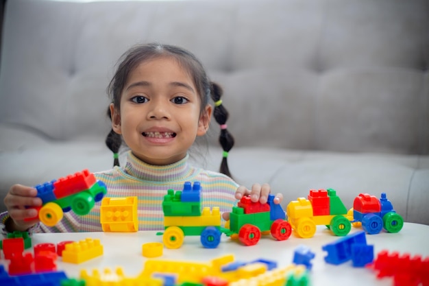 Adorable little girl playing toy blocks in a bright roomx9