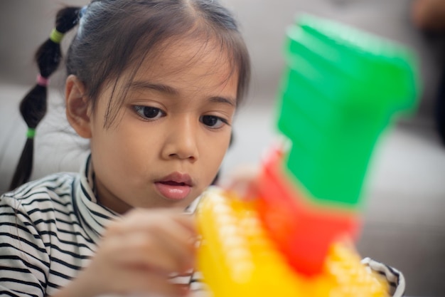 Adorable little girl playing toy blocks in a bright roomx9