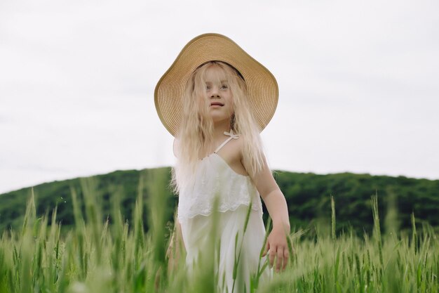 暖かい夏の日に麦畑で遊ぶ愛らしい少女