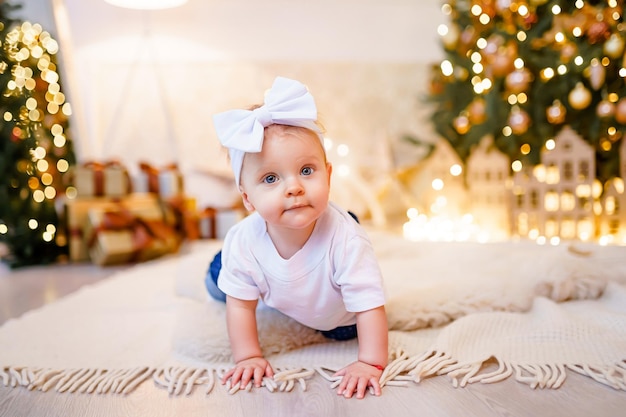 Adorable little girl playing with ornaments under decorated Christmas tree