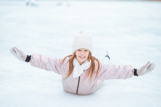 Adorable little girl skating on the ice-rink