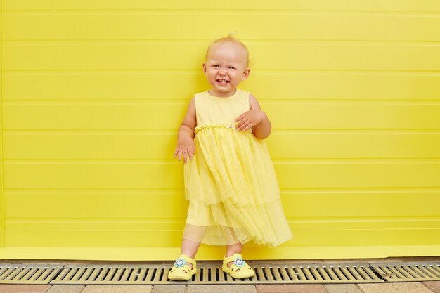 Adorabile bambina sorridente su sfondo giallo.