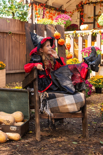 美しい秋のdaのカボチャパッチで楽しんでいるハロウィーンの衣装を着ている愛らしい少女