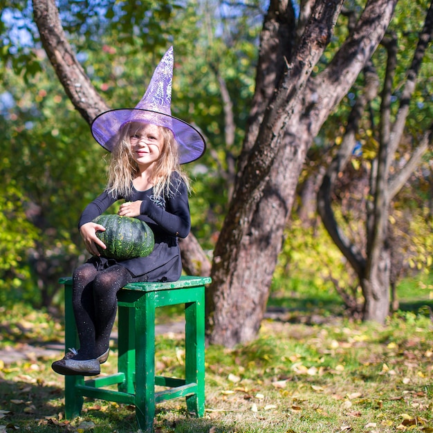 Adorable little girl in witch costume on Halloween