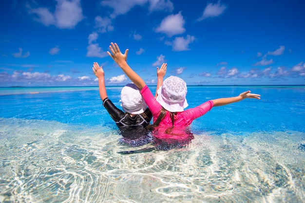 Adorable little girls playing in outdoor swimming pool