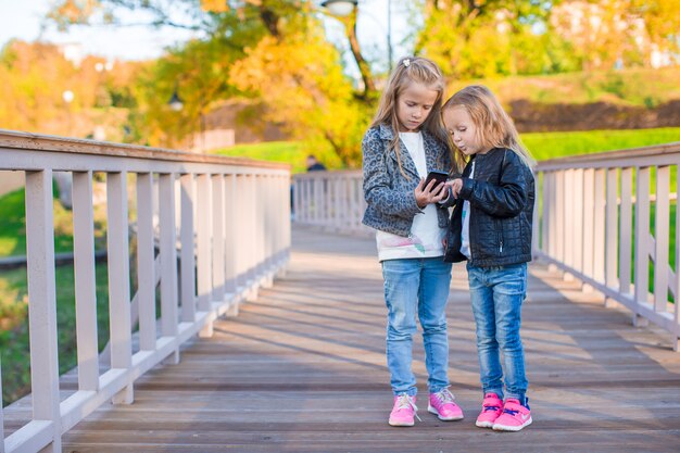 Adorable little girls at warm autumn day outdoors