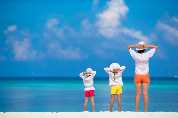 熱帯の白いビーチで愛らしい小さな女の子や若い母親