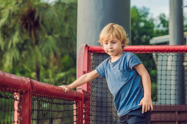 遊び場で楽しんでいる愛らしい小さな幼児の男の子